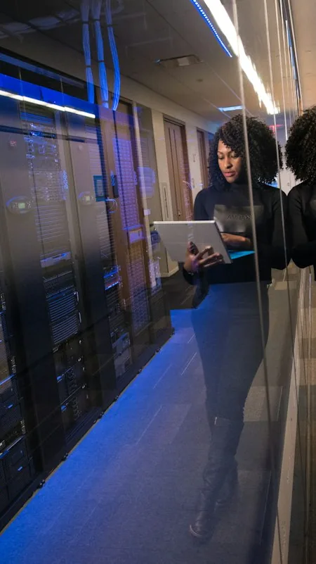 Responsable informatique circulant dans un couloir de baies de serveurs